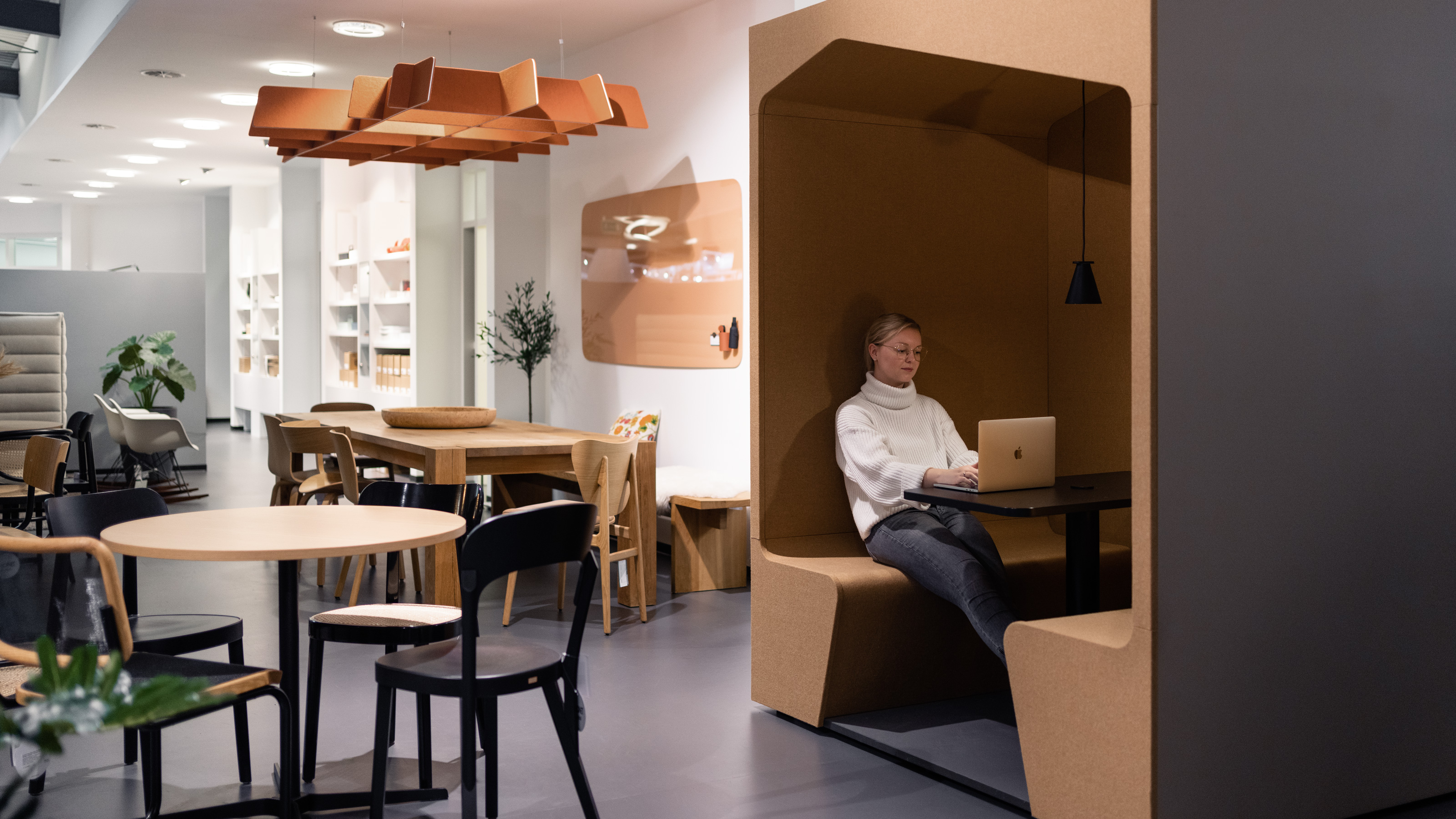 Alisa Ostermann sitzt mit Macbook in Werner Works Schrankkoje